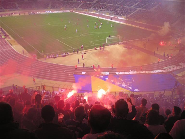 Soccer supporters standing and cheering in a stadium