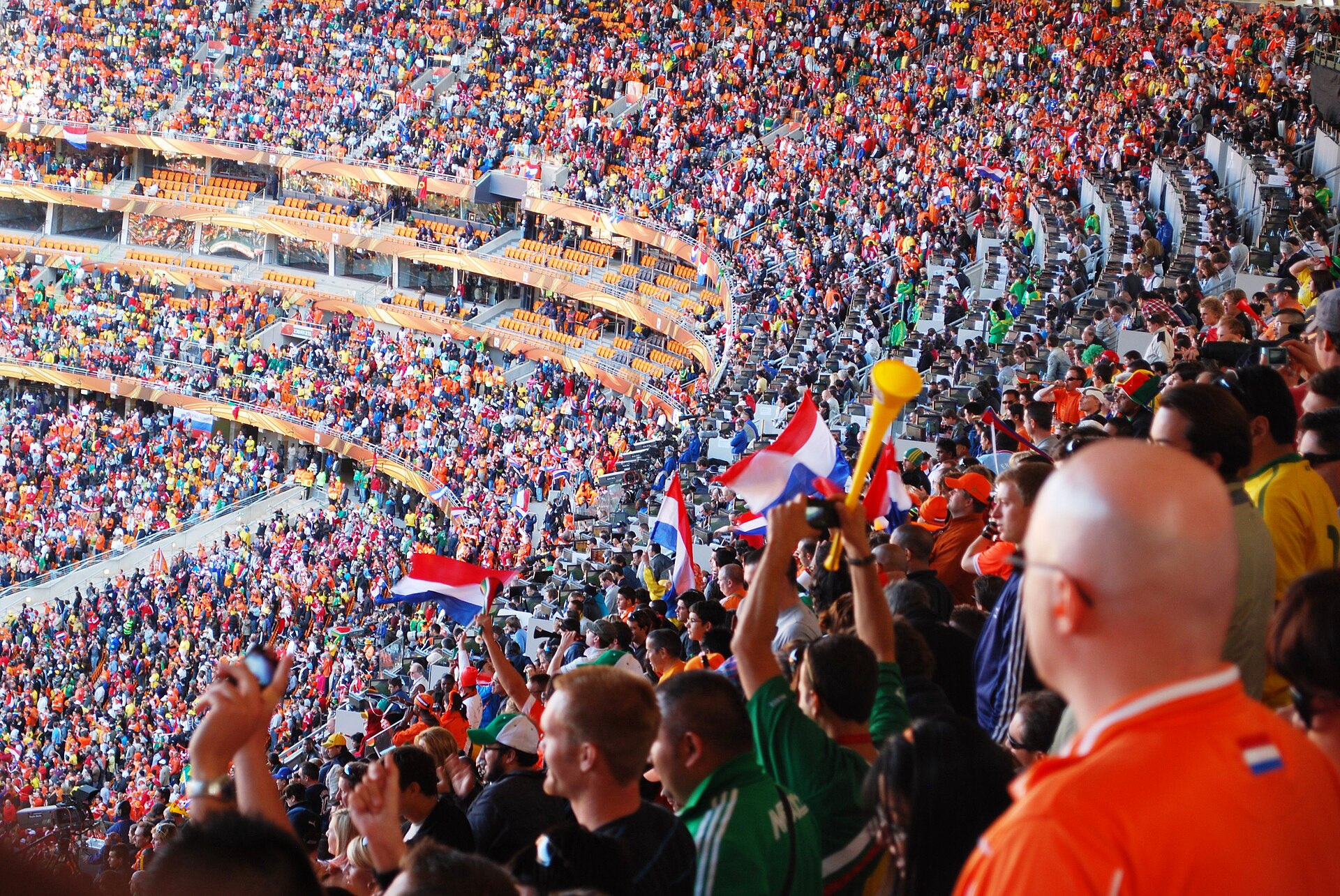 Soccer fans cheering in a packed match crowd